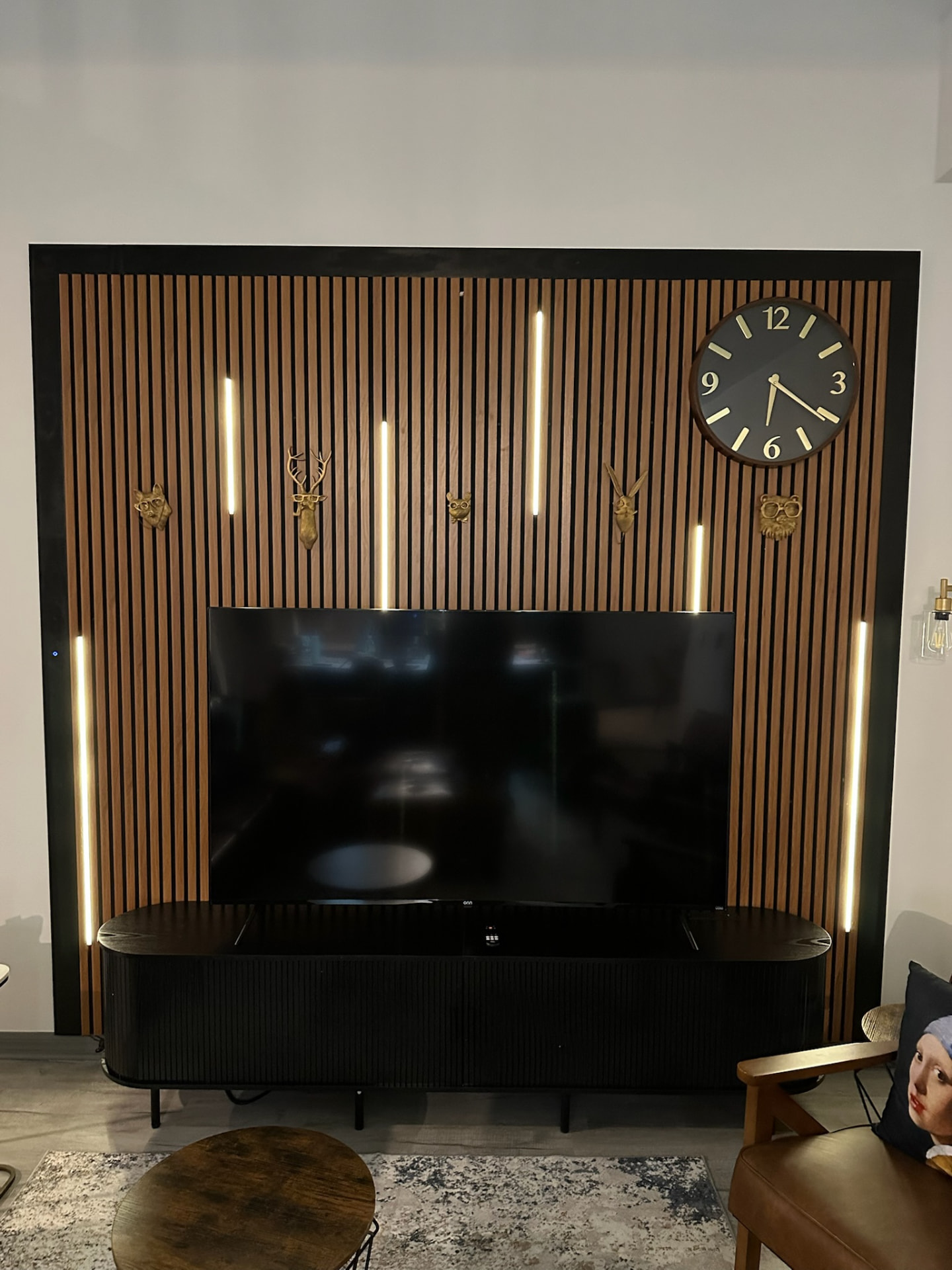 Wooden slat wall behind the TV with warm accent lights at Highgate Dream
